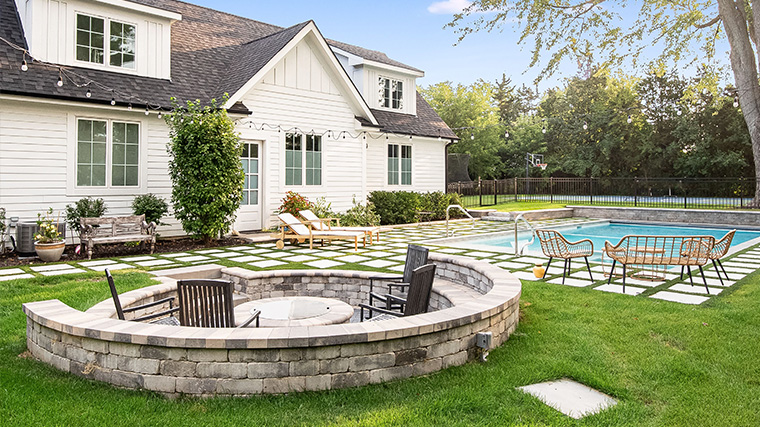 Backyard oasis featuring a green pool with energy-efficient LED lighting and native plant integration.