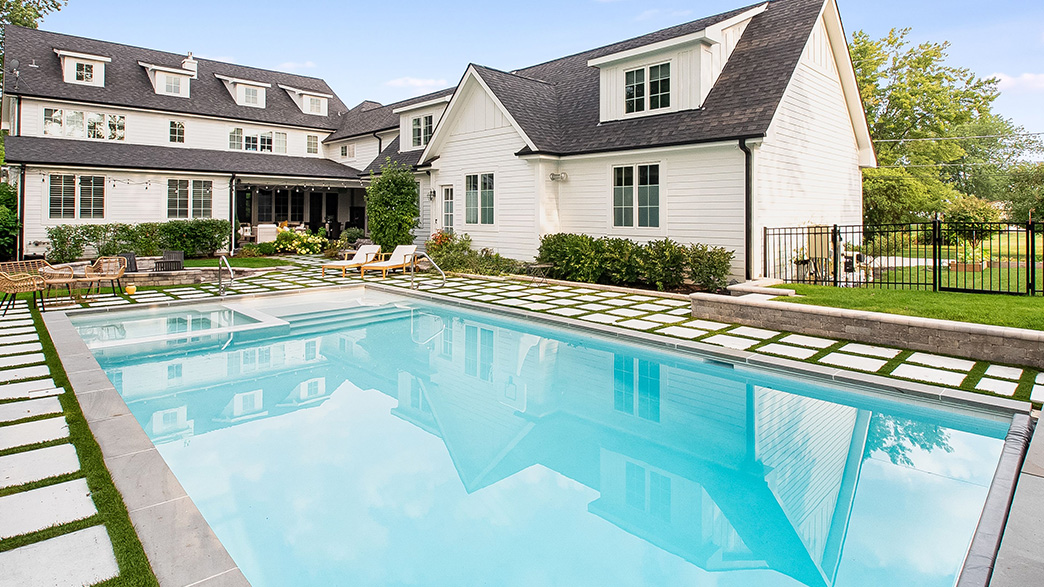 Eco-friendly backyard pool with solar heating panels and sustainable landscaping by Sunset Pools & Spas.